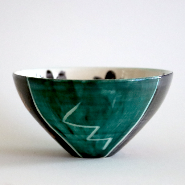 Green ceramic bowl with a zigzag pattern on a white background